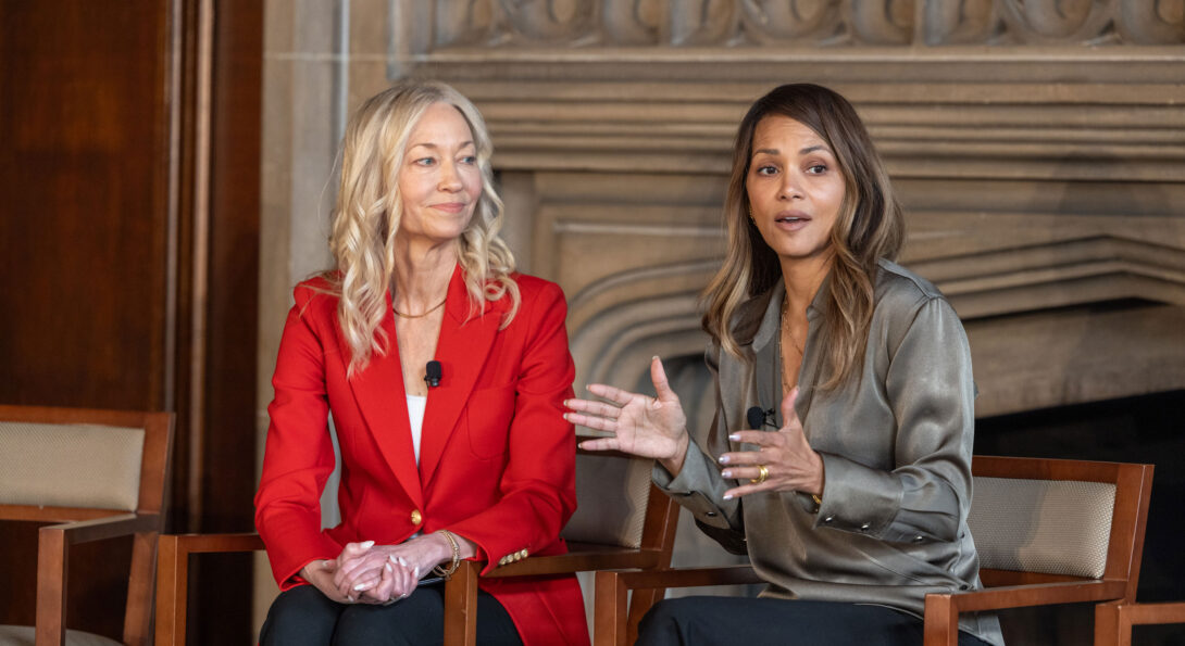 Halle Berry speaking to an audience as she sits next to Dr. Maki