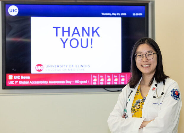 A doctor standing in front of a monitor that says Thank You